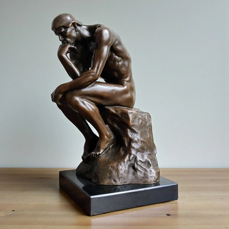 Bronzová socha „Myslitel“ podle A. Rodina na mramorovém podstavci (Le Penseur)